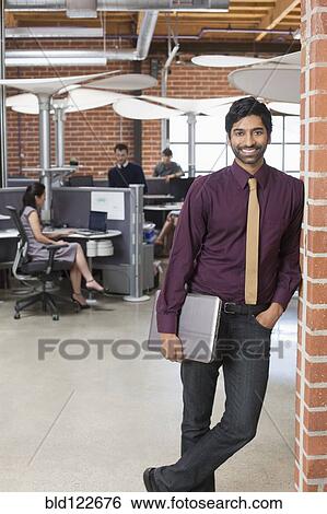 Stock Photograph - Businessman smiling in office. Fotosearch