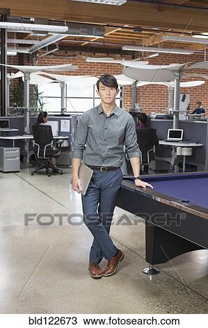 Businessman standing in office lounge area View Large Photo Image Stock Image - Businessman standing in office lounge area. Fotosearch