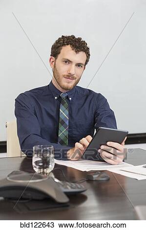 Caucasian businessman using digital tablet in office View Large Photo Image Stock Image - Caucasian businessman using digital tablet in office. Fotosearch