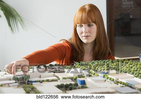 Caucasian businesswoman examining scale model View Large Photo Image Stock Photograph - Caucasian businesswoman examining scale model. Fotosearch
