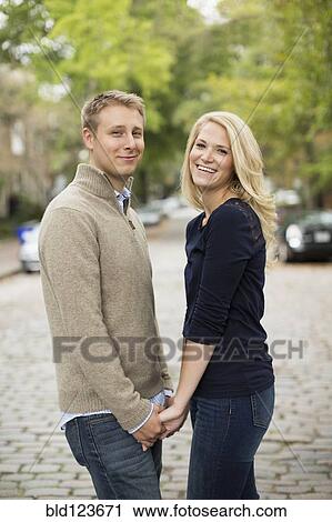 Stock Image - Caucasian couple holding hands outdoors. Fotosearch