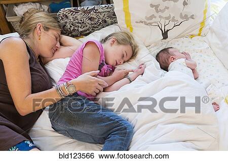 Caucasian family sleeping on bed View Large Photo Image Stock Photograph - Caucasian family sleeping on bed. Fotosearch