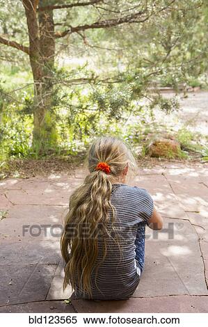 Stock Photography - Caucasian girl sitting outdoors. Fotosearch
