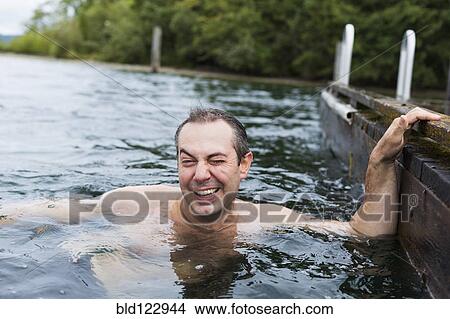 Picture - Caucasian man swimming in lake. Fotosearch