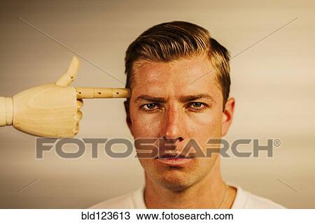 Caucasian man with wooden finger pointed at head View Large Photo Image Stock Image - Caucasian man with wooden finger pointed at head. Fotosearch