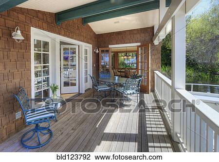 Stock Image - Chairs and table on wooden patio. Fotosearch