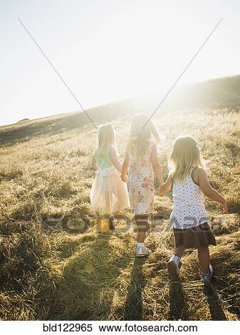 Stock Photography - Children holding hands in rural field. Fotosearch