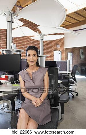Chinese businesswoman smiling in office View Large Photo Image Stock Photograph - Chinese businesswoman smiling in office. Fotosearch