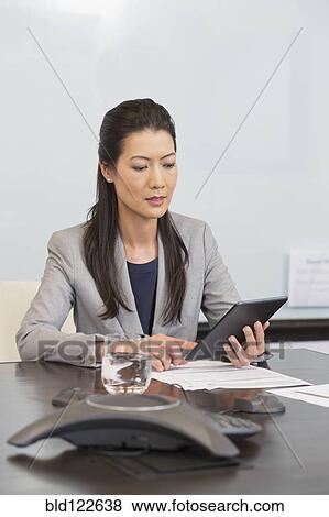 Chinese businesswoman using digital tablet in office View Large Photo Image Stock Photo - Chinese businesswoman using digital tablet in office. Fotosearch