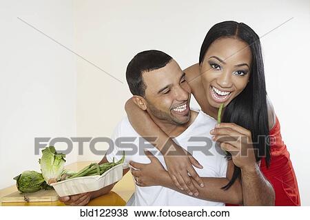 Stock Photo - Couple eating vegetables together. Fotosearch