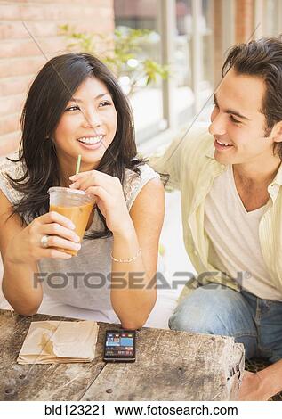 Couple enjoying iced coffee at sidewalk cafe View Large Photo Image Stock Image - Couple enjoying iced coffee at sidewalk cafe. Fotosearch