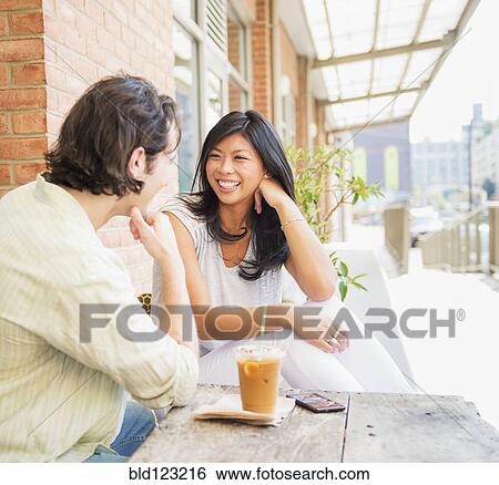 Stock Photograph - Couple enjoying iced coffee at sidewalk cafe. Fotosearch