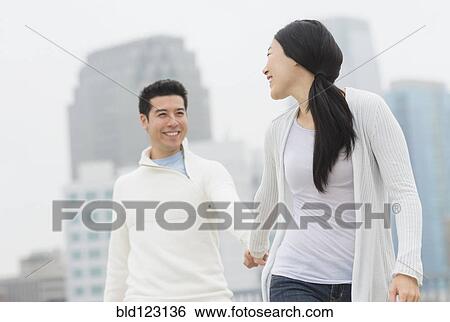 Couple holding hands in city View Large Photo Image Stock Photograph - Couple holding hands in city. Fotosearch