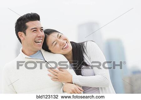Stock Image - Couple hugging in city. Fotosearch