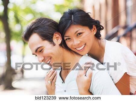Stock Photo - Couple hugging on urban sidewalk. Fotosearch