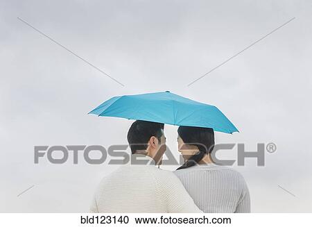 Couple hugging under umbrella View Large Photo Image Stock Image - Couple hugging under umbrella. Fotosearch