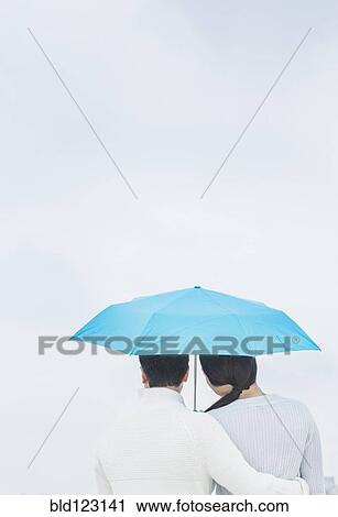 Couple hugging under umbrella View Large Photo Image Stock Image - Couple hugging under umbrella. Fotosearch
