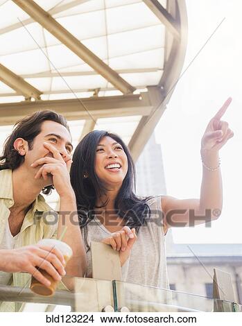 Couple pointing and looking up View Large Photo Image Picture - Couple pointing and looking up. Fotosearch
