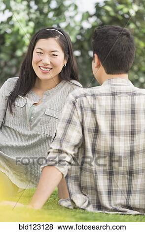 Couple relaxing together in grass View Large Photo Image Stock Photo - Couple relaxing together in grass. Fotosearch