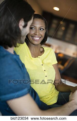 Picture - Couple relaxing together on sofa. Fotosearch
