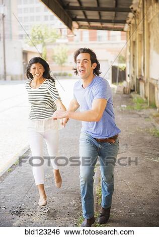 Stock Photograph - Couple running on urban street. Fotosearch