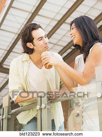Couple sharing iced coffee outdoors View Large Photo Image Stock Image - Couple sharing iced coffee outdoors. Fotosearch