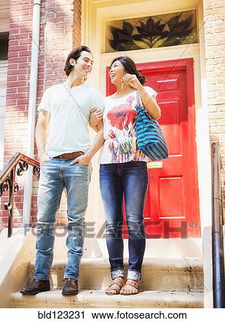 Couple standing on front stoop with house key View Large Photo Image Stock Image - Couple standing on front stoop with house key. Fotosearch