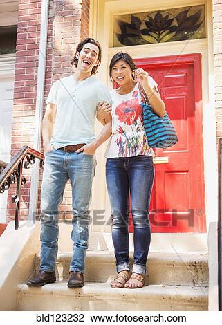 Couple standing on front stoop with house key View Large Photo Image Stock Image - Couple standing on front stoop with house key. Fotosearch