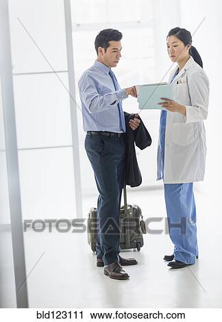 Doctor and businessman talking in hospital View Large Photo Image Stock Image - Doctor and businessman talking in hospital. Fotosearch