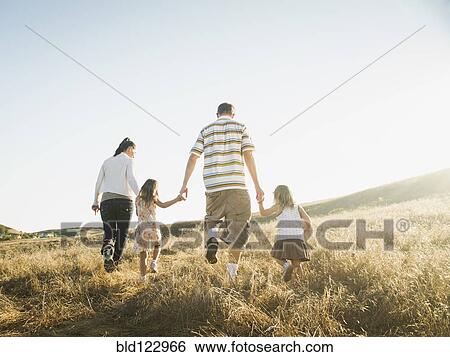 Family walking together in rural field View Large Photo Image Stock Photograph - Family walking together in rural field. Fotosearch