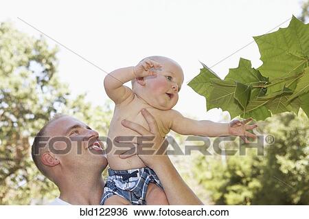 Father holding baby outdoors View Large Photo Image Stock Photograph - Father holding baby outdoors. Fotosearch