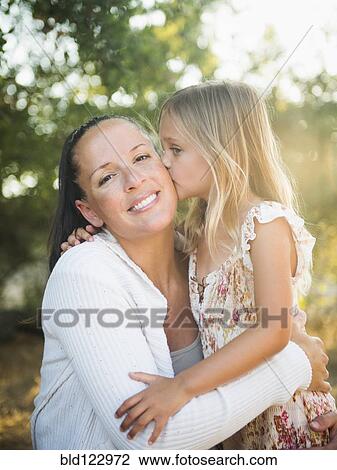 Girl kissing mother outdoors View Large Photo Image Stock Image - Girl kissing mother outdoors. Fotosearch