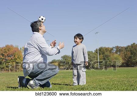 Hispanic father and son playing soccer outdoors View Large Photo Image Stock Image - Hispanic father and son playing soccer outdoors. Fotosearch
