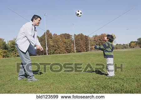 Hispanic father and son playing soccer outdoors View Large Photo Image Stock Photo - Hispanic father and son playing soccer outdoors. Fotosearch