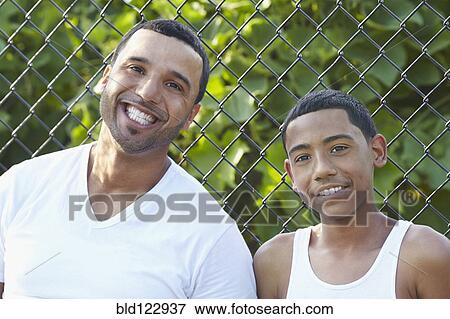 Stock Photo - Hispanic father and son smiling outdoors. Fotosearch