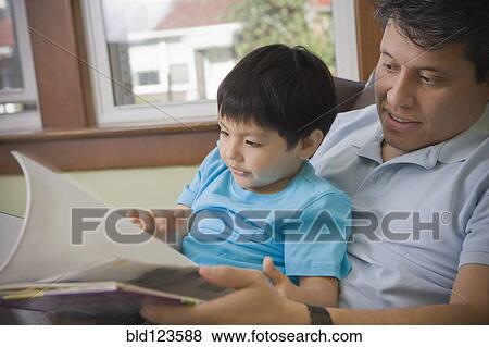 Hispanic father reading to son View Large Photo Image Stock Photo - Hispanic father reading to son. Fotosearch