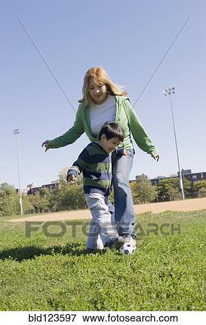 Hispanic mother and son playing soccer outdoors View Large Photo Image Stock Photo - Hispanic mother and son playing soccer outdoors. Fotosearch