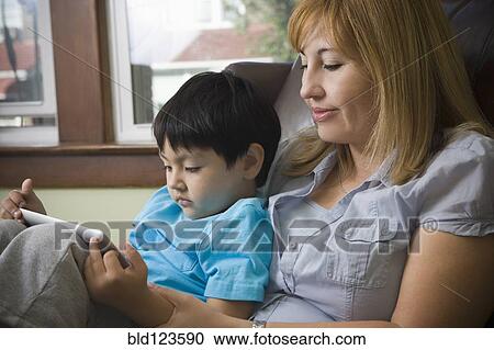 Stock Image - Hispanic mother reading to son. Fotosearch