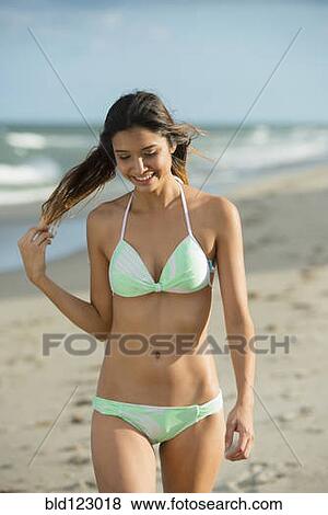 Stock Photo - Hispanic woman walking on beach. Fotosearch