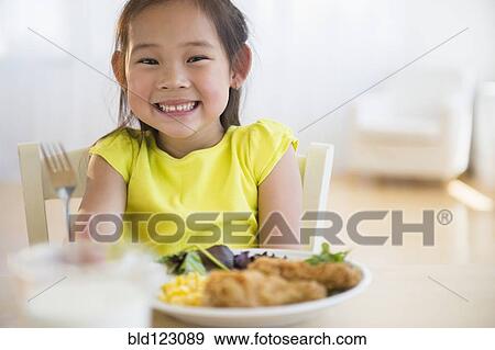 Stock Photo - Korean girl eating dinner at table. Fotosearch