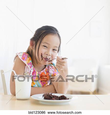 Stock Photograph - Korean girl eating slice of chocolate cake. Fotosearch