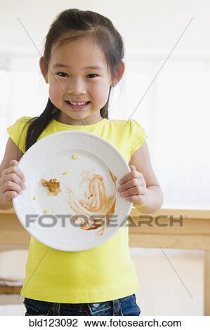 Stock Image - Korean girl showing cleared plate. Fotosearch