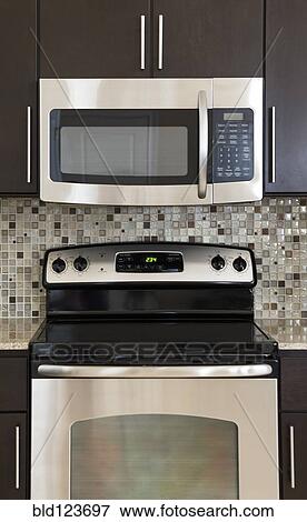 Stock Photo - Microwave and stove in modern kitchen. Fotosearch