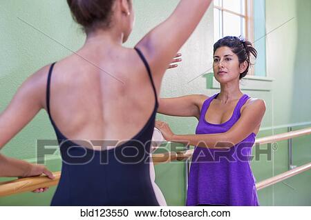 Mixed race ballerina practicing with teacher at barre View Large Photo Image Stock Image - Mixed race ballerina practicing with teacher at barre. Fotosearch