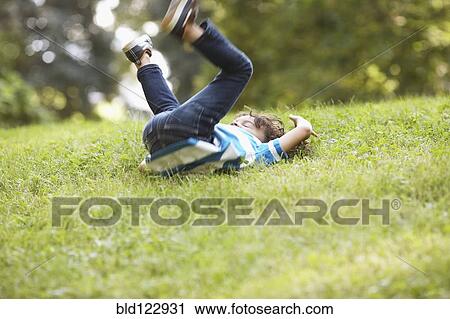Stock Image - Mixed race boy playing in grass. Fotosearch