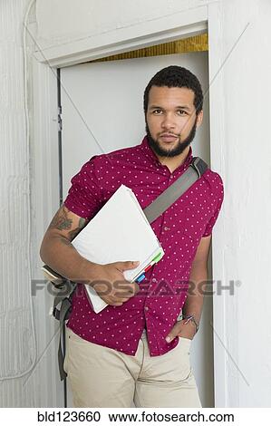 Mixed race businessman holding binder in doorway View Large Photo Image Stock Image - Mixed race businessman holding binder in doorway. Fotosearch