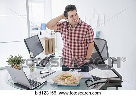 Mixed race businessman smiling at desk View Large Photo Image Stock Photograph - Mixed race businessman smiling at desk. Fotosearch