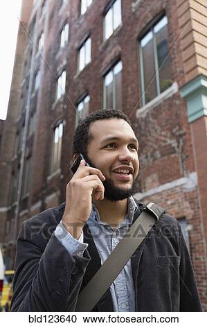 Mixed race businessman talking on cell phone in city View Large Photo Image Stock Image - Mixed race businessman talking on cell phone in city. Fotosearch