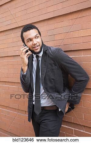 Mixed race businessman talking on cell phone outdoors View Large Photo Image Stock Photograph - Mixed race businessman talking on cell phone outdoors. Fotosearch