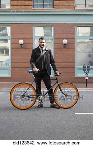 Mixed race businessman with bicycle on city street View Large Photo Image Stock Image - Mixed race businessman with bicycle on city street. Fotosearch